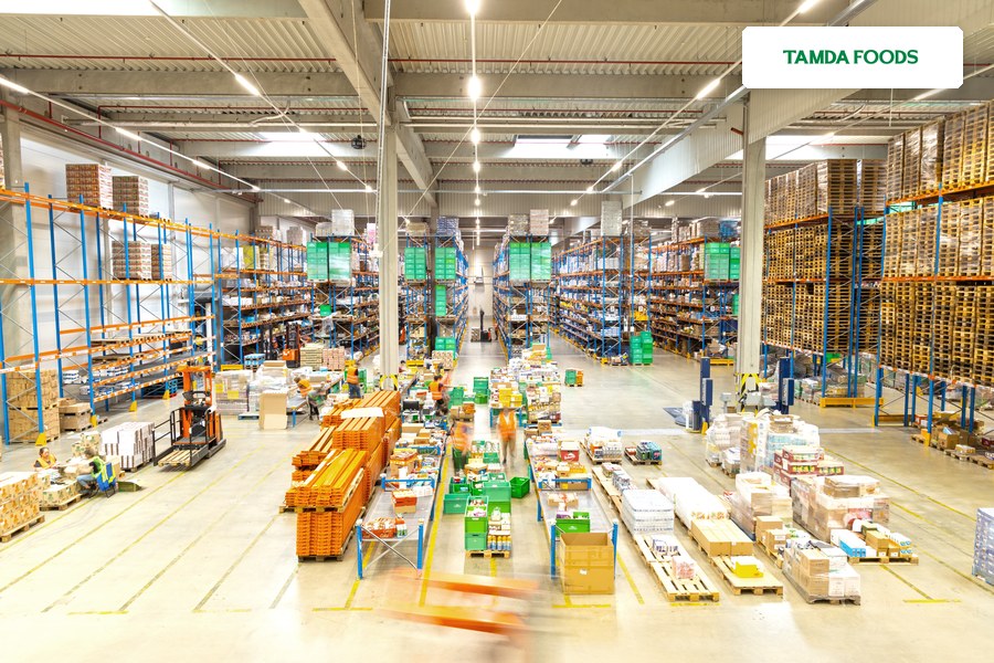 Sklad Tamda Foods s regály plnými zboží na paletách