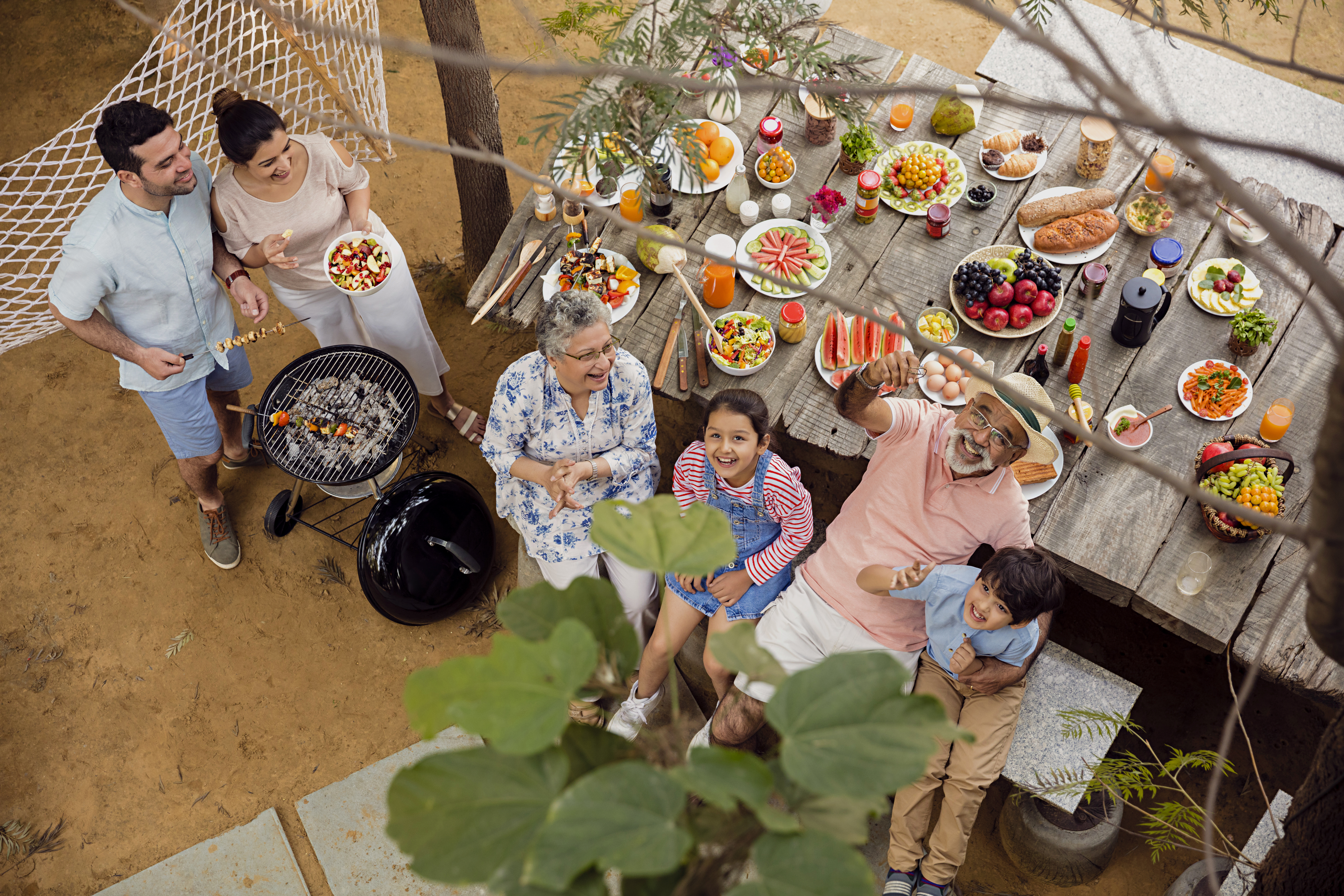 family-is-gathered-around-table-with-potted-plant-pot-fruit.jpg