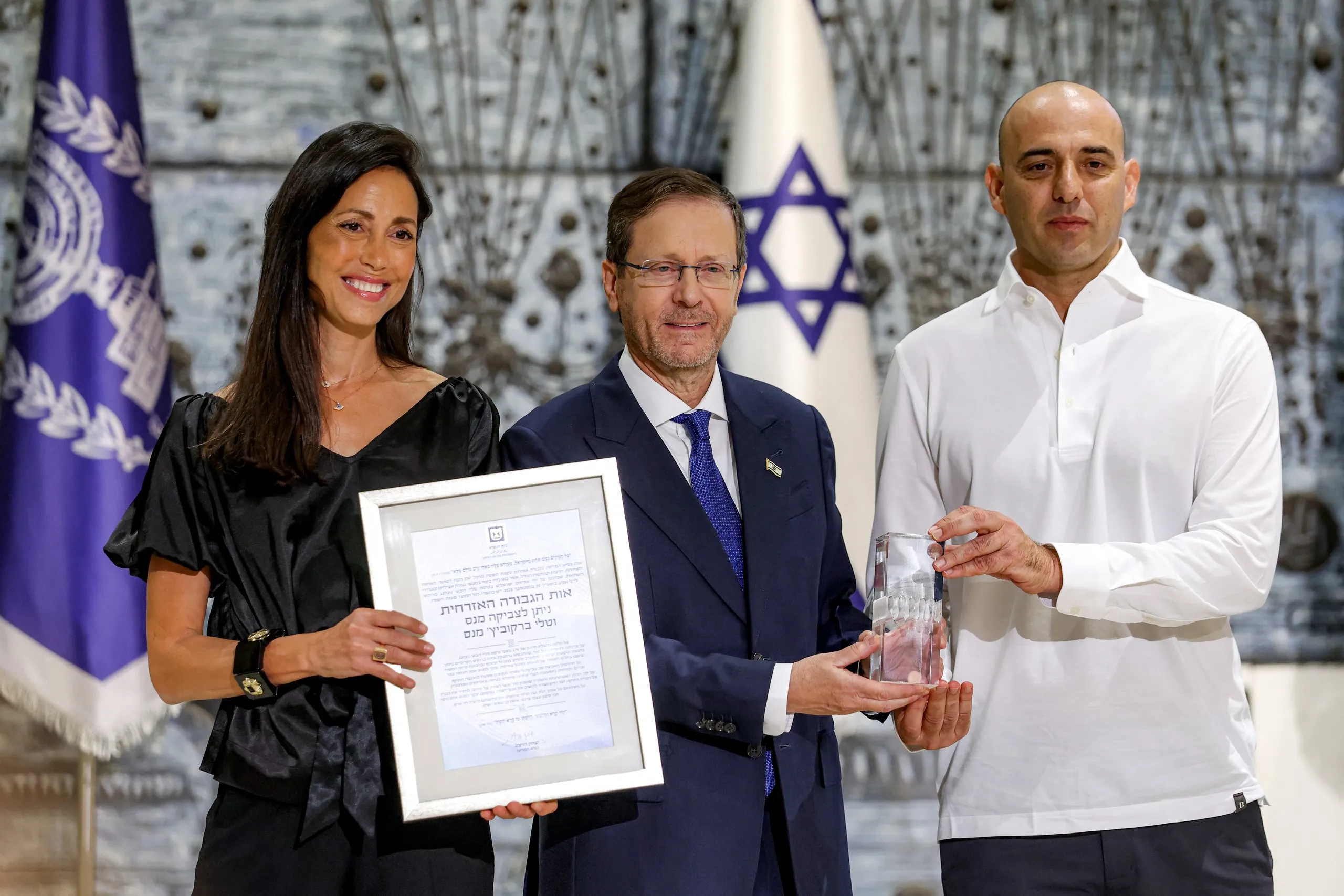 Tổng thống Israel Isaac Herzog (giữa) trao Huân chương Anh hùng dân sự cho vợ chồng Tali (trái) và Zvika Manes (phải), hai trong số các hành khách Israel đã can thiệp khống chế cơ phó trên chuyến bay Flydubai FZ1073, tại dinh tổng thống ở Jerusalem ngày 8-10 - Ảnh: AFP