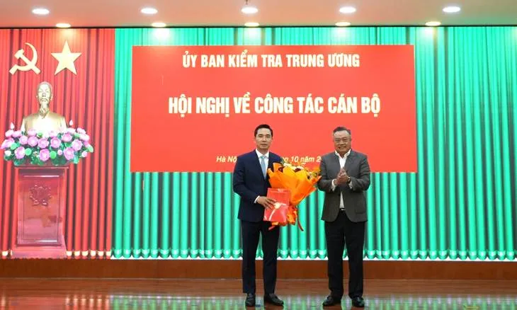 Chủ nhiệm Ủy ban Kiểm tra Trung ương Trần Sỹ Thanh trao quyết định và tặng hoa chúc mừng ông Trần Văn Phúc - Ảnh: UBKT Trung ương