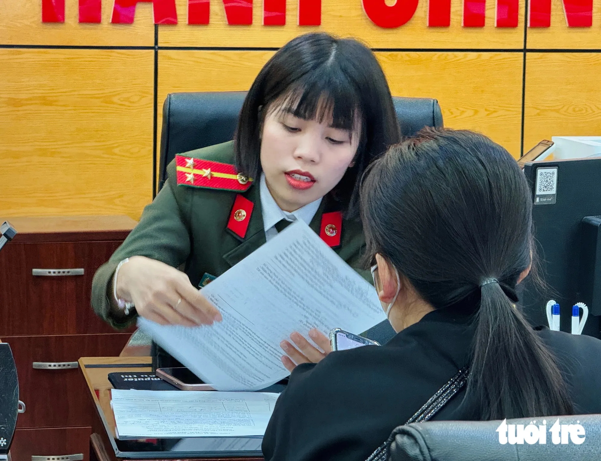 Cán bộ công an hướng dẫn công dân thực hiện thủ tục hành chính - Ảnh: DANH TRỌNG