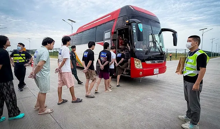 Các công dân nước ngoài lên xe buýt dưới sự giám sát của lực lượng chức năng trước khi bị trục xuất khỏi Campuchia - Ảnh: Tổng cục Di trú Campuchia (GDI)