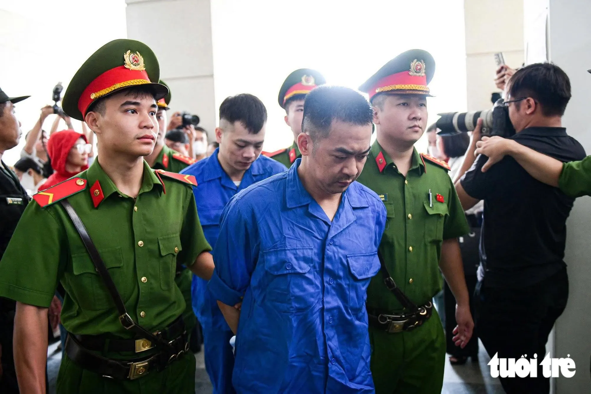 Các bị cáo bị dẫn giải đến phiên tòa - Ảnh: NAM TRẦN