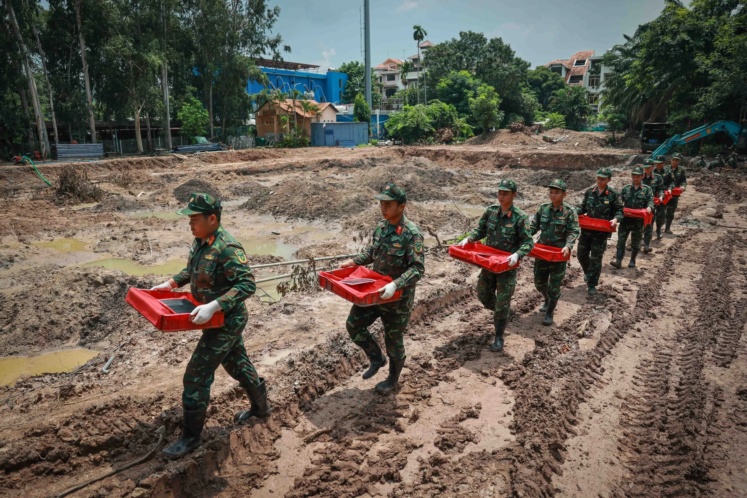Các chiến sĩ Đội K74 đưa hài cốt liệt sĩ vừa tìm thấy về khu vực lấy mẫu trong công viên Lê Thị Riêng. Kết quả trong ngày 1-10, tại Khu B, lực lượng làm nhiệm vụ đã phát hiện, quy tập được 19 bộ hài cốt liệt sĩ - Ảnh: NGUYỄN KHÁNH