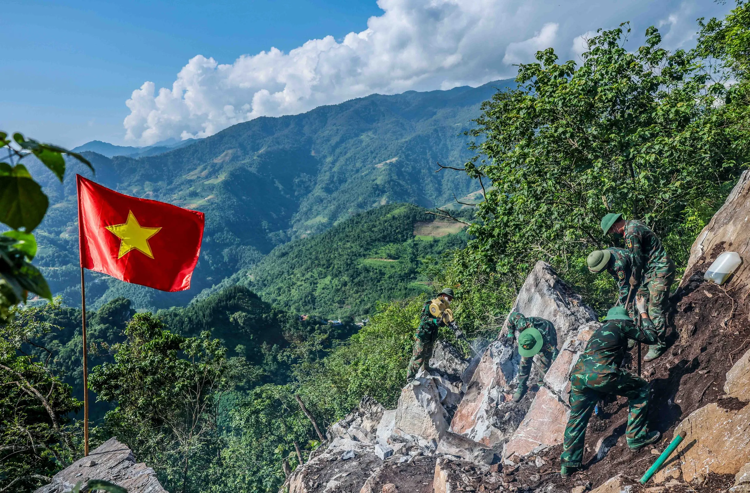 Các thành viên thuộc Đội tìm kiếm và quy tập hài cốt liệt sĩ - Bộ Chỉ huy Quân sự tỉnh Tuyên Quang khoan đá tại khu vực hang sập cao điểm 685, vị trí này được các cựu chiến binh cho biết nhiều khả năng còn nhiều liệt sĩ nằm lại - Ảnh: NGUYỄN KHÁNH