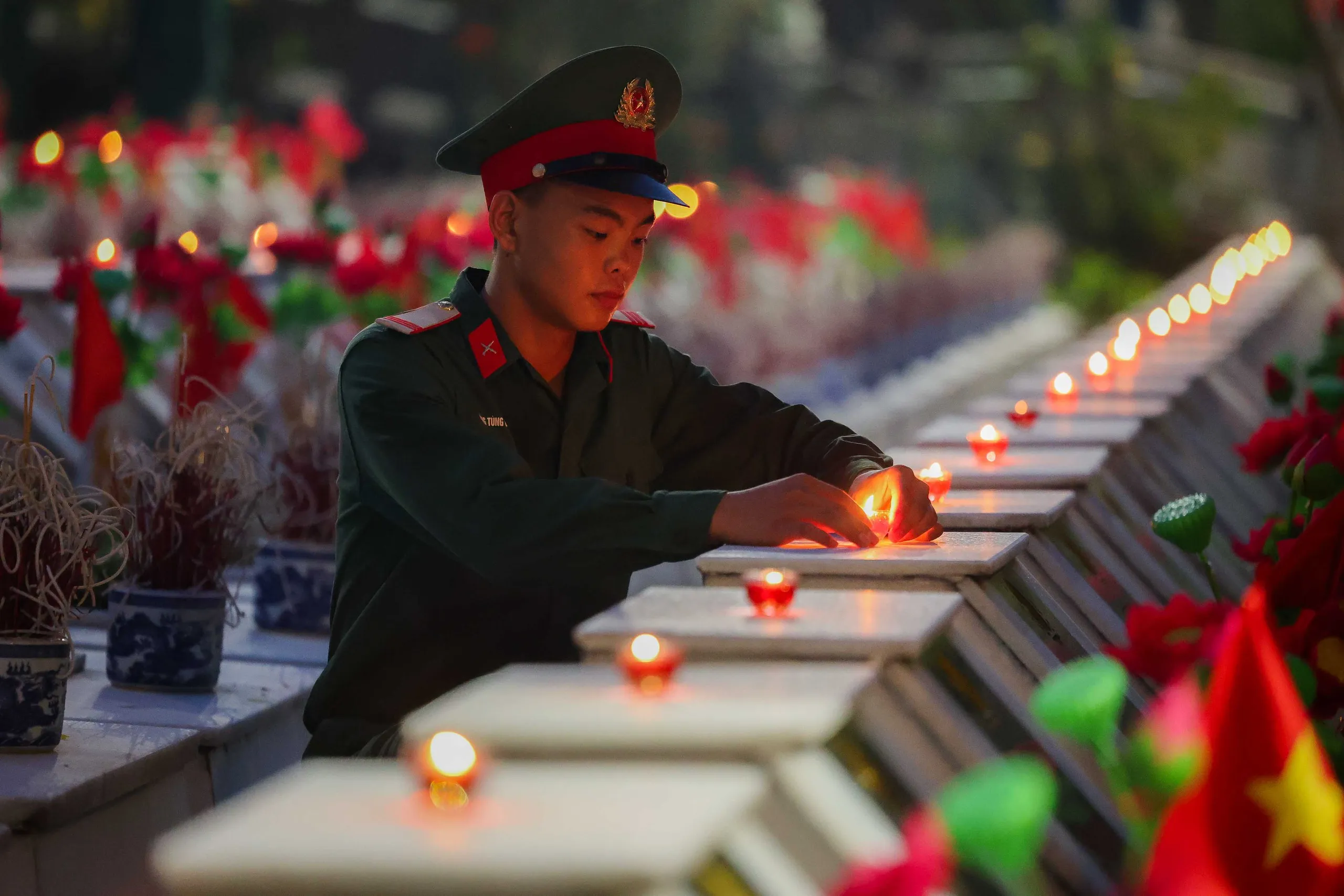 Chiến sĩ Vàng Tùng Dương, Trung đoàn bộ binh 877, thuộc Bộ Chỉ huy quân sự tỉnh Tuyên Quang, thắp nến tri ân tưởng nhớ đến các liệt sĩ tại nghĩa trang Quốc gia Vị Xuyên - Ảnh: NGUYỄN KHÁNH
