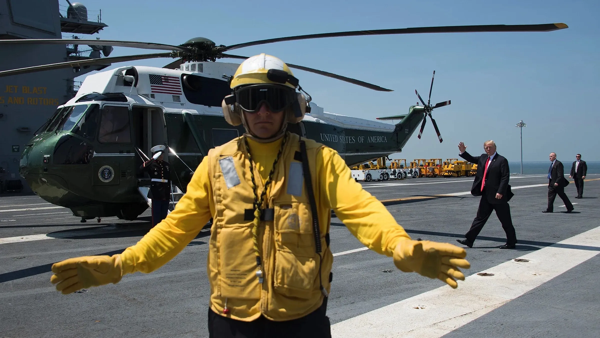 Tổng thống Donald Trump (phía sau) vẫy tay chào khi rời tàu sân bay USS Gerald R. Ford tại Norfolk, Virginia, hồi tháng 7/2017.