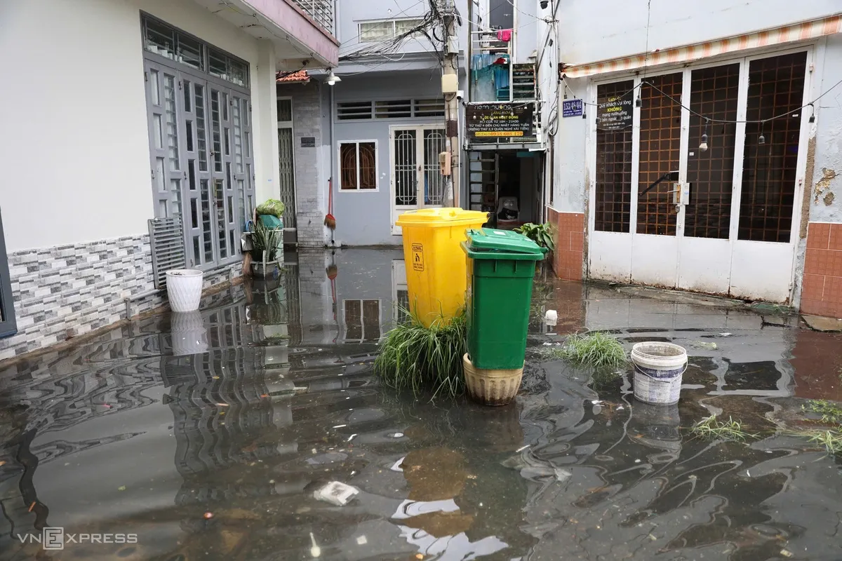 Tại hẻm 153 đường Lê Văn Thọ, nước vẫn chưa rút, người dân phải đặt cả thùng rác lên cao để tránh trôi dạt.