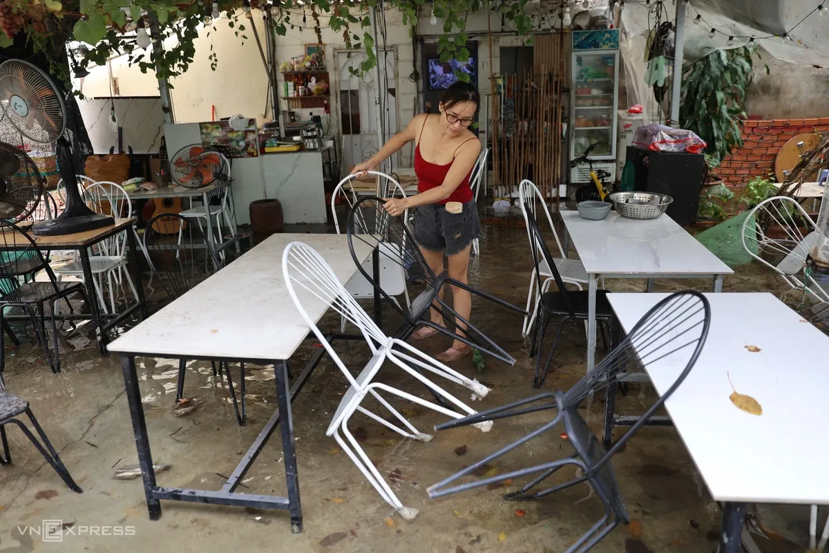 Nước tràn vào quán, chị Minh Vương phải tạm đóng cửa để dọn dẹp.
