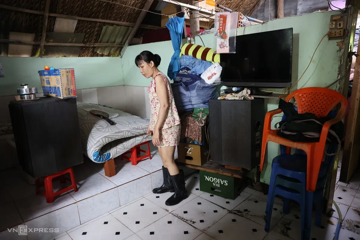 Trên đường Nguyễn Văn Khối, nhiều con hẻm vẫn chìm trong nước dù mưa đã tạnh từ tối qua. Ngập nặng nhất là hẻm 171, nơi nhiều nhà dân, hàng quán bị nước tràn vào.
Sáng nay, nền nhà bà Nguyễn Đoàn Thanh Trúc vẫn còn xâm xấp nước. Bà kể tối qua, chỉ sau nửa giờ mưa lớn, cả nhà đã phải tất bật di chuyển đồ đạc lên cao.