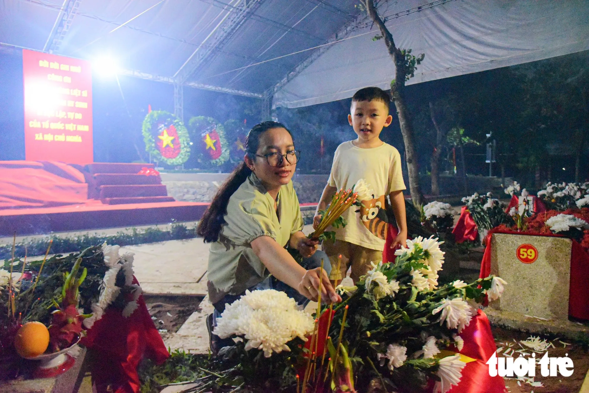 Em nhỏ theo mẹ đến dâng hương cho các anh hùng liệt sĩ vừa được an táng ở Nghĩa trang Liệt sĩ TP.HCM tối 14-10 - Ảnh: TRÍ ĐỨC