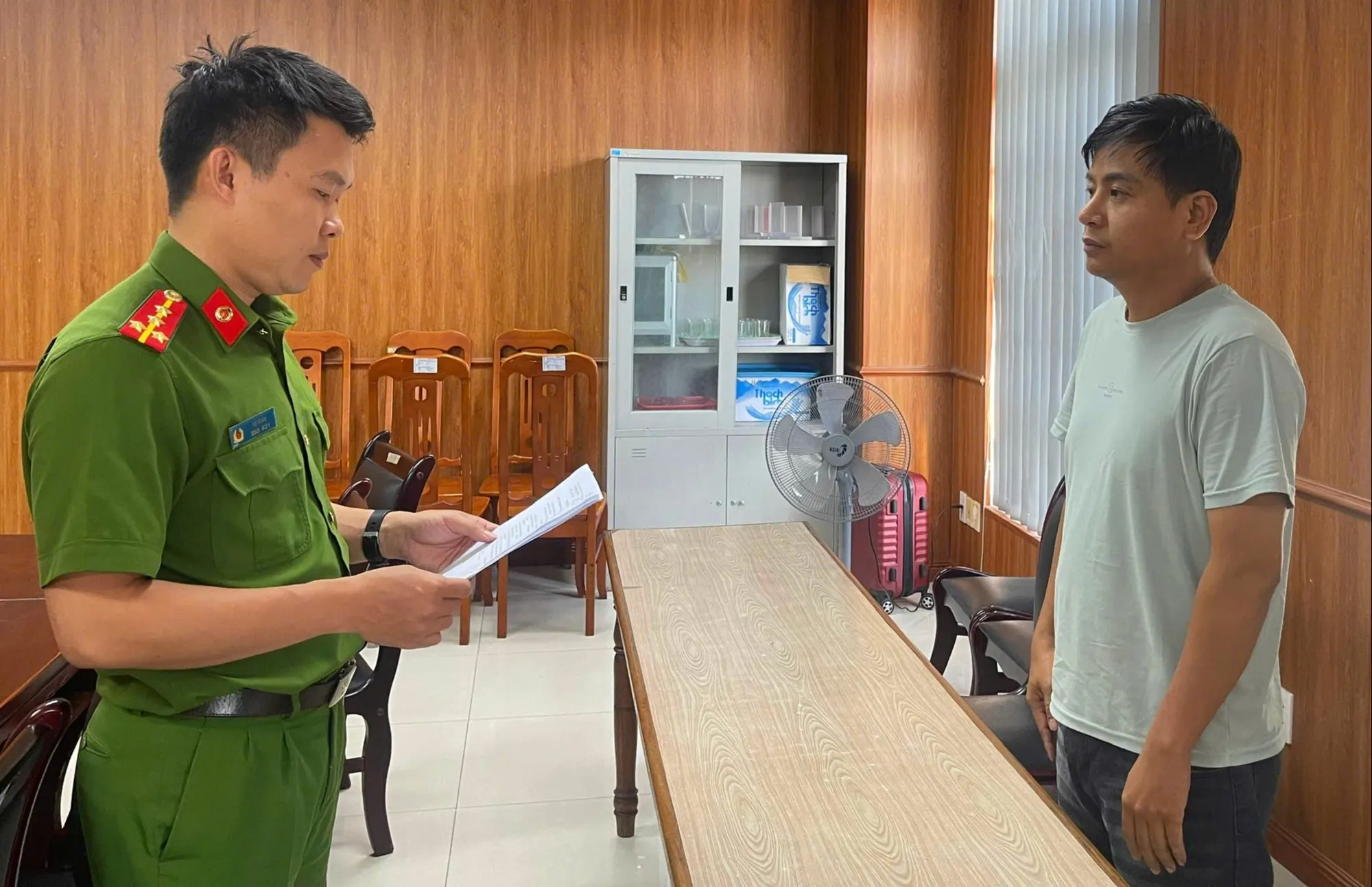 Cơ quan điều tra tống đạt các quyết định - Ảnh: H.B.