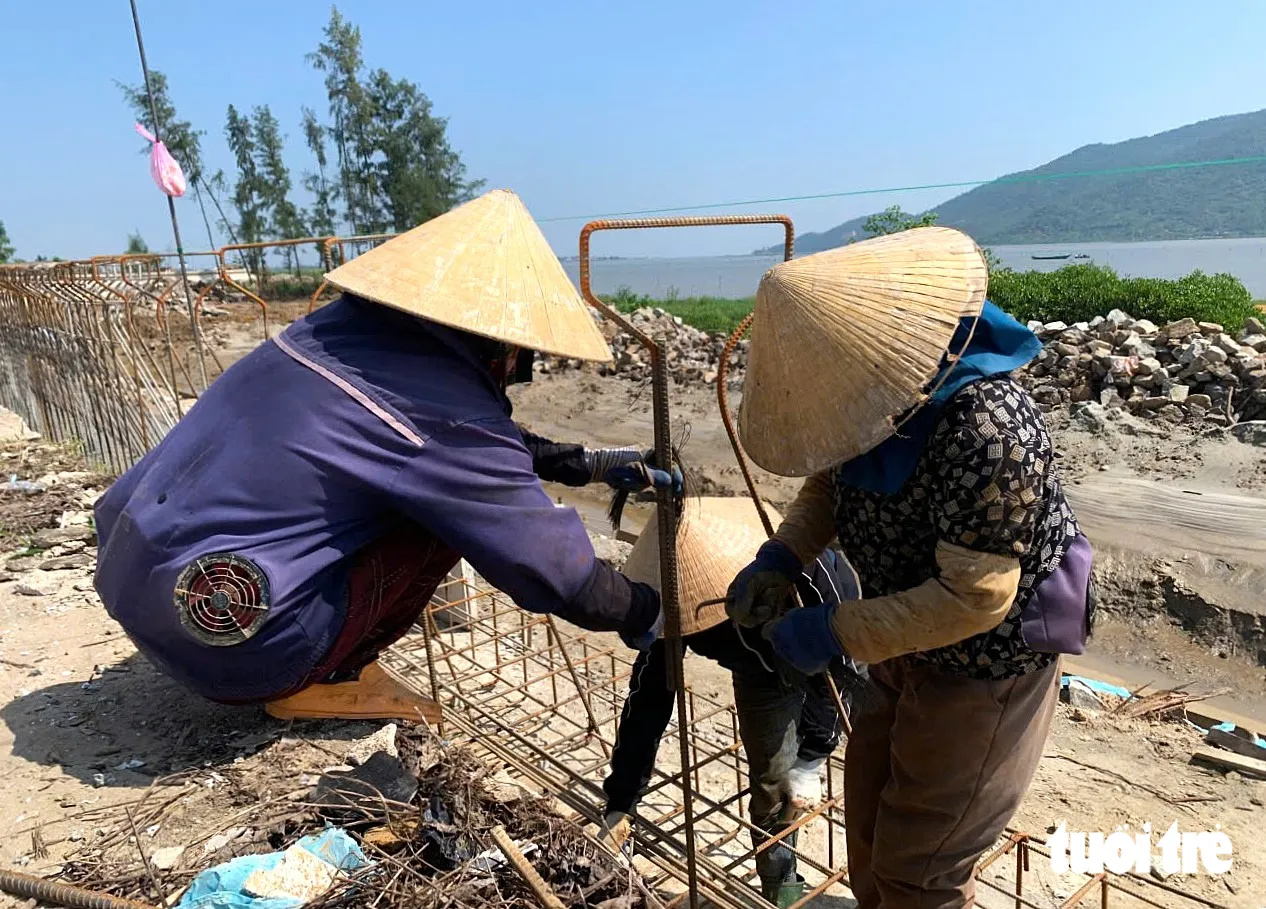 Những người phụ nữ được thuê đến buộc sắt tại dự án khôi phục, sửa chữa đê Tả Nghèn đoạn qua phường Trần Phú và xã Mai Phụ - Ảnh: LÊ MINH
