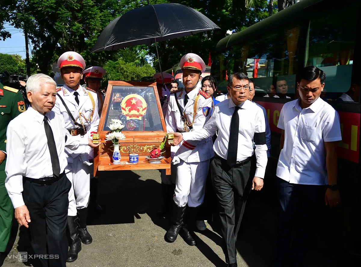 Thủ tướng Lê Minh Hưng cùng nguyên Chủ tịch nước Nguyễn Minh Triết dẫn đầu đoàn đưa các quách đựng hài cốt liệt sĩ ra xe, chuẩn bị di chuyển đến Nghĩa trang liệt sĩ TP HCM để an táng.