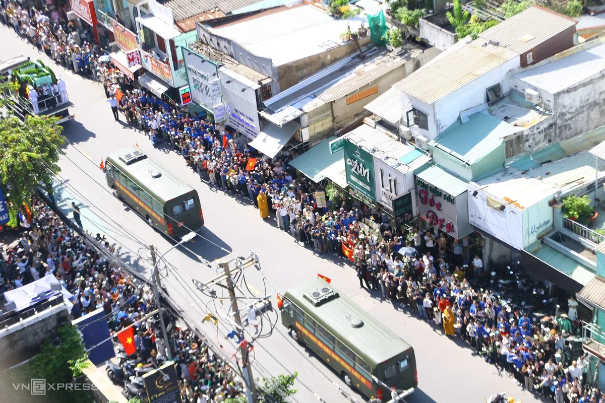 Đoàn xe chở hài cốt liệt sĩ qua đường Trường Sơn, Cách Mạng Tháng Tám về nơi an táng. Hai bên đường, đông đảo người dân và cán bộ, chiến sĩ đứng tiễn.
