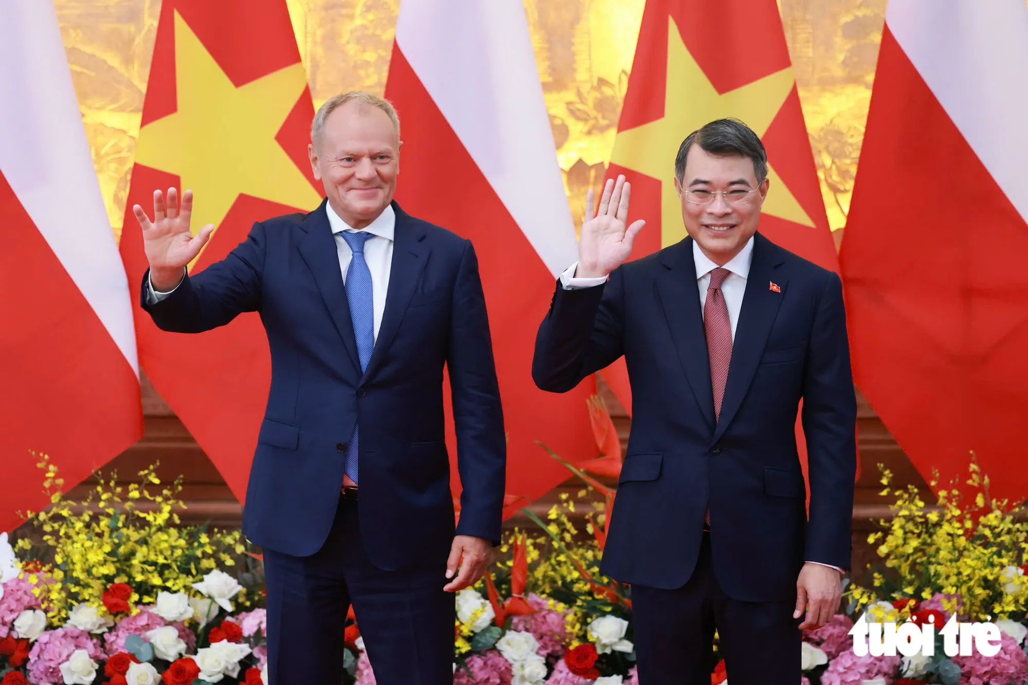 Thủ tướng Lê Minh Hưng và Thủ tướng Ba Lan Donald Tusk vẫy tay chào báo chí trước khi gặp hẹp - Ảnh: NGUYỄN KHÁNH