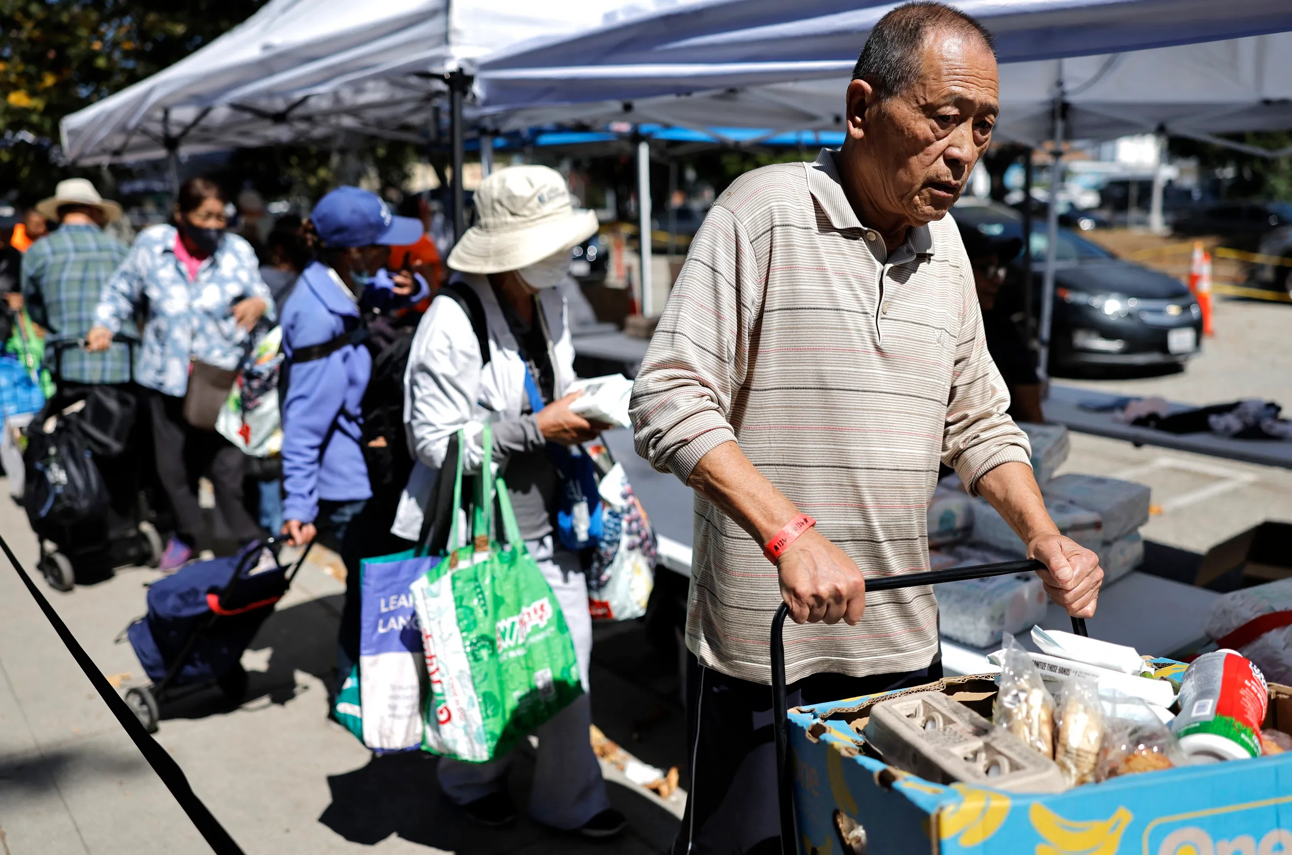 Người dân ở thành phố Pasadena, bang California xếp hàng chờ nhận thực phẩm miễn phí - Ảnh: AFP