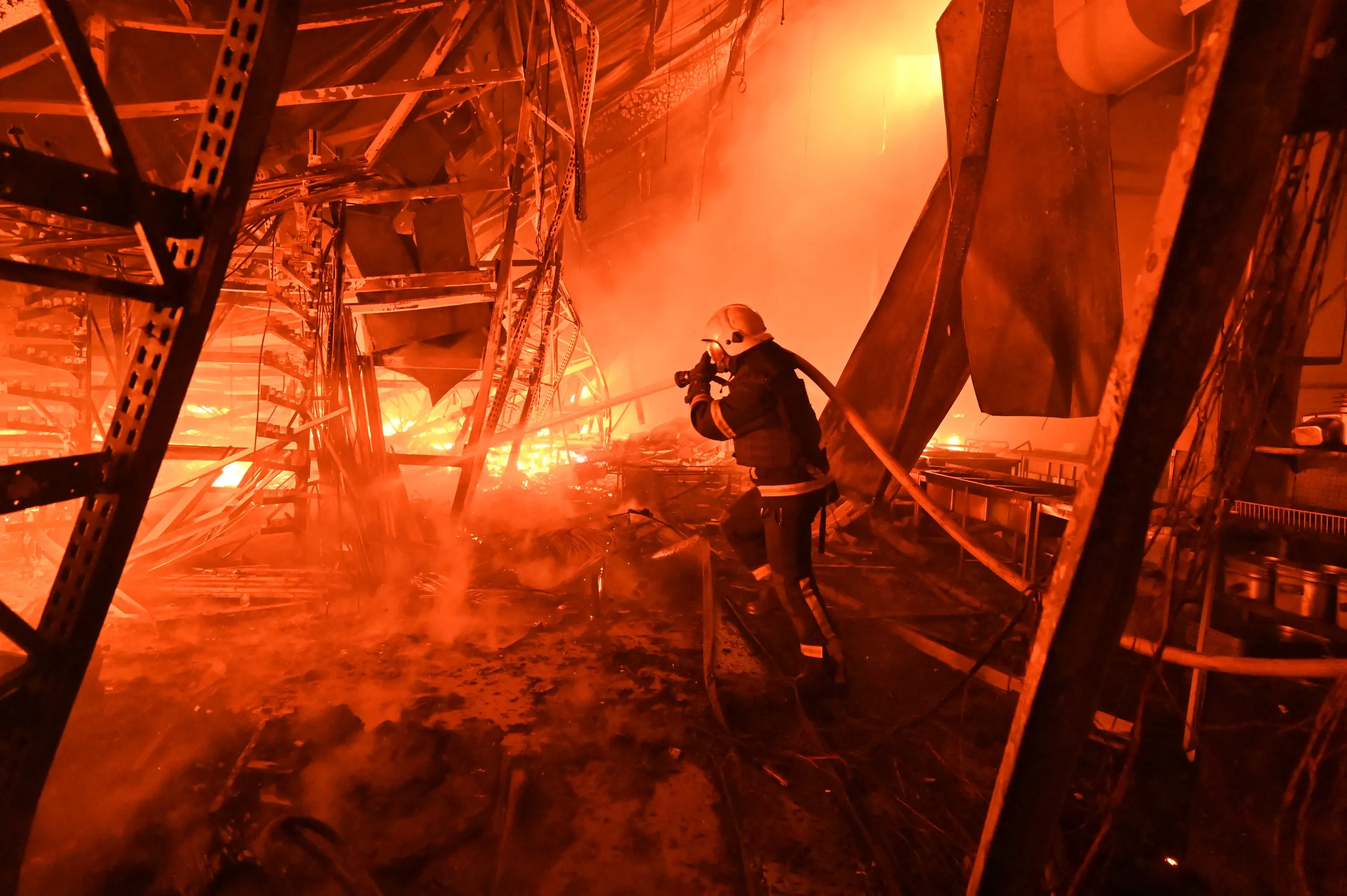 Lính cứu hỏa Ukraine dập lửa sau cuộc không kích của Nga vào Kharkov tối 24-10 - Ảnh: AFP