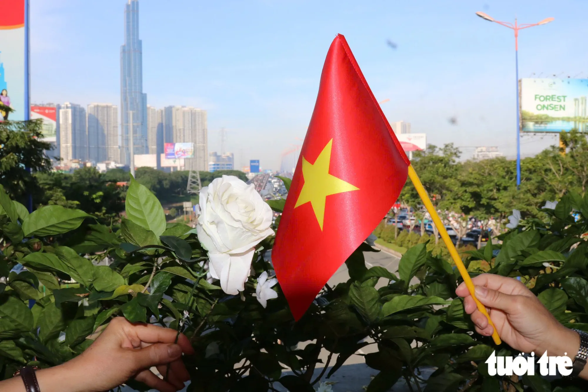 Nhành hoa trắng dành cho những người đã khuất, lá cờ đỏ sao vàng dành cho những người đã hy sinh vì non sông. Trong khoảnh khắc các anh trở về, lòng biết ơn như lan tỏa giữa đất trời - Ảnh: NGỌC LÂN