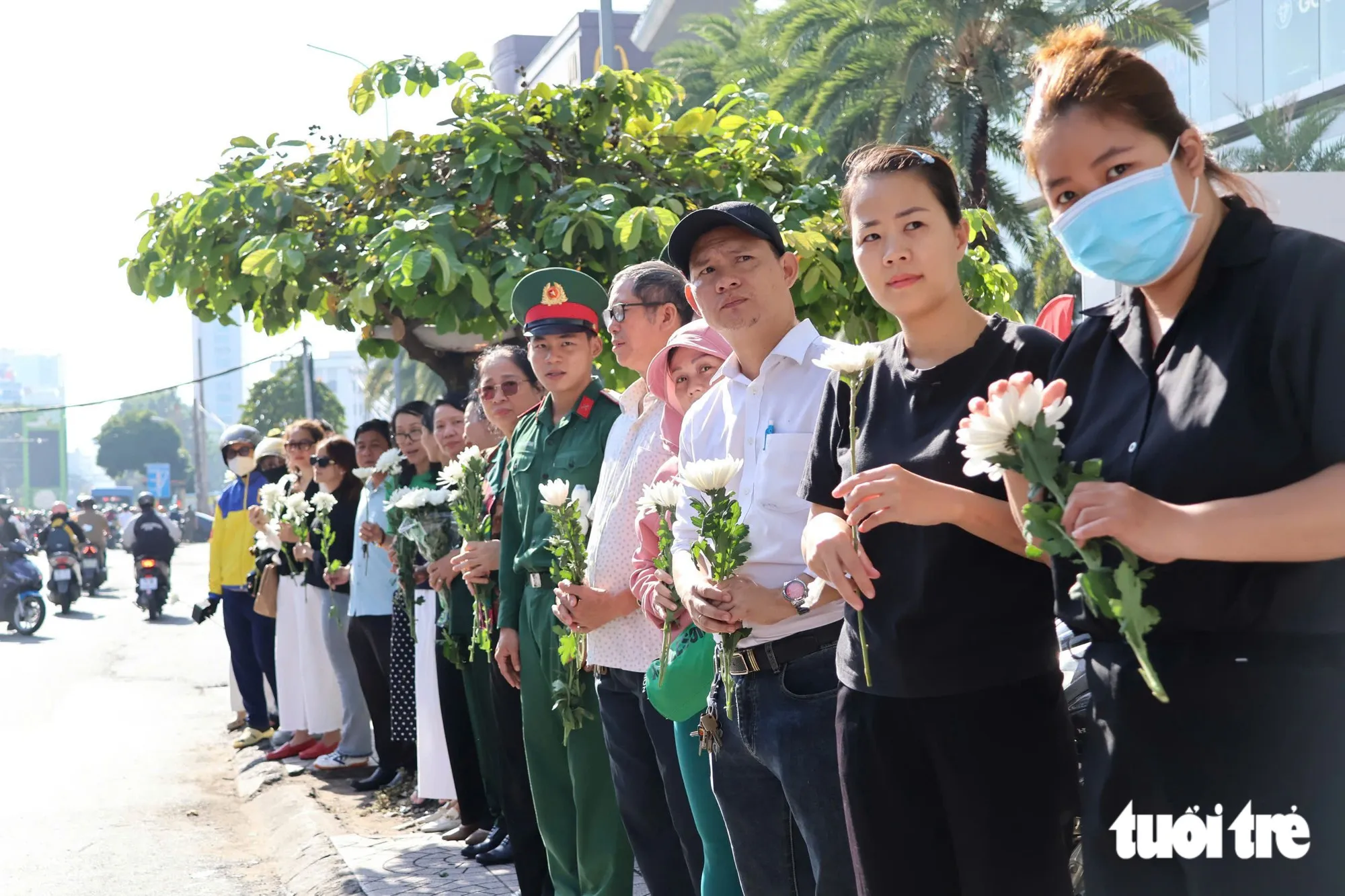 Lúc 8h, trên đường Cách Mạng Tháng 8, bà con đã có mặt để chờ xe chở hài cốt liệt sĩ đi qua - Ảnh: ĐẶNG LINH
