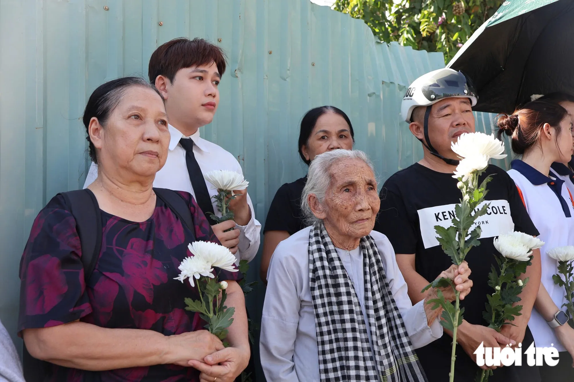 Bà Võ Thị Vân (98 tuổi - đeo khăn rằn), cựu chiến binh, hôm nay cũng có mặt để đưa tiễn những người đồng đội về nơi an nghỉ cuối cùng - Ảnh: ĐẶNG LINH