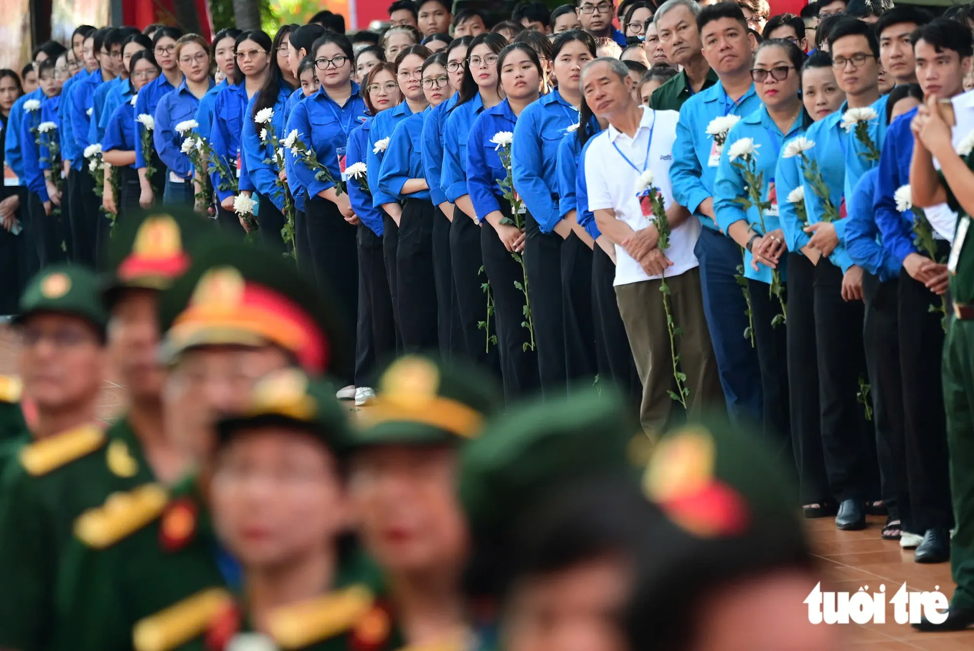 Đoàn viên thanh niên thành kính chờ đưa tiễn các anh hùng liệt sĩ ở công viên Lê Thị Riêng về nơi an táng - Ảnh: TRÍ ĐỨC
