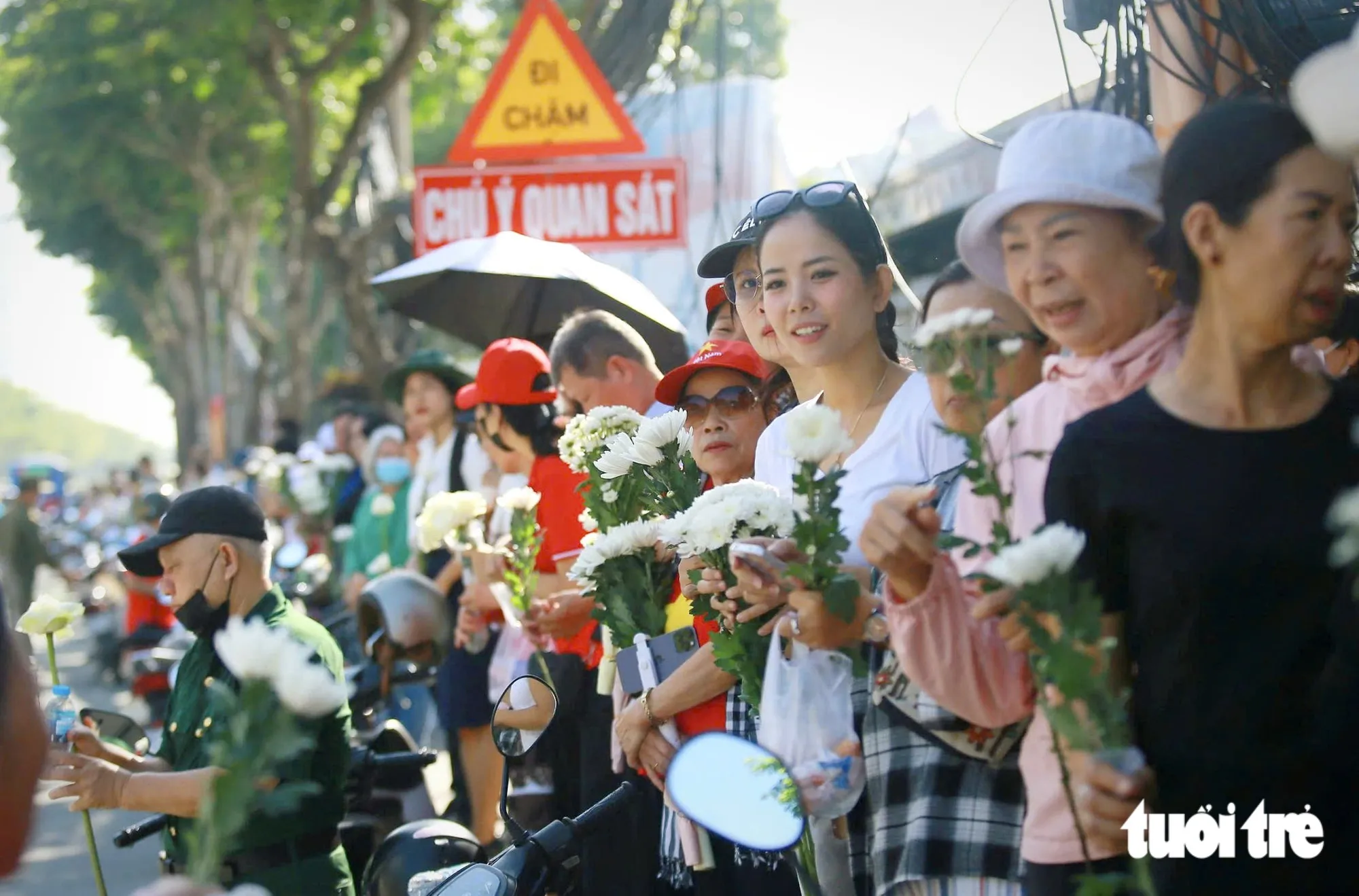 Khoảng 8h30, quanh ga metro Thảo Điền (thuộc tuyến metro số 1), rất đông người đến chờ đoàn xe đưa hài cốt liệt sĩ đi qua. Người đứng trên cầu bộ hành, người tập trung dưới chân cầu và hai bên đường Võ Nguyên Giáp. Nhiều người chọn chỗ đứng từ sớm, mắt hướng về phía cầu Sài Gòn để chờ đoàn xe - Ảnh: CHÂU TUẤN