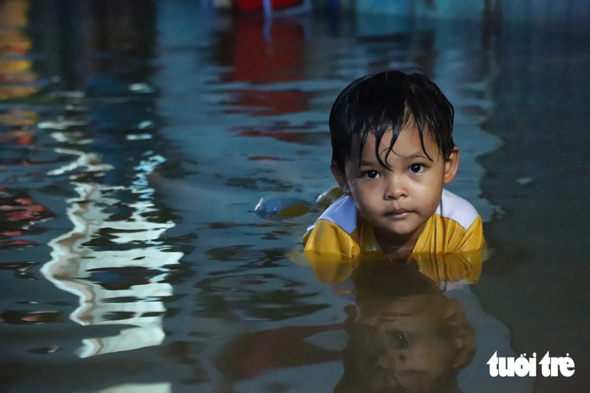 Em bé hồn nhiên bơi giữa dòng nước triều cường dâng tại hẻm 142 đường Võ Nguyên Giáp (phường Bình Trưng, TP.HCM)- Ảnh: NGỌC LÂN