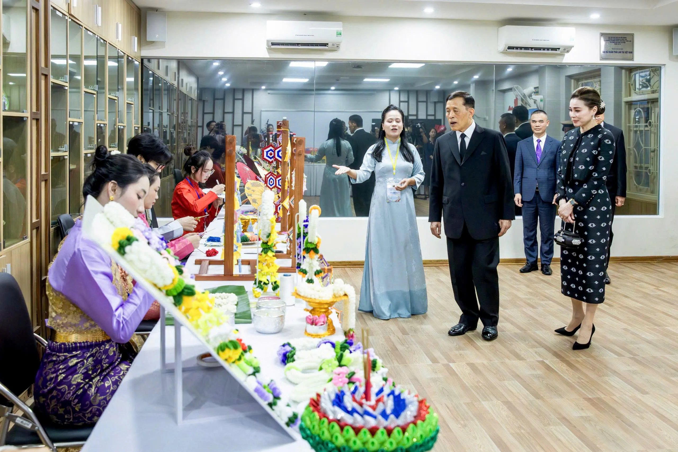 Nhà vua Thái Lan và Hoàng hậu xem một số sản phẩm thủ công truyền thống Thái Lan do sinh viên Trường Đại học Hà Nội làm - Ảnh: HẢI HUY