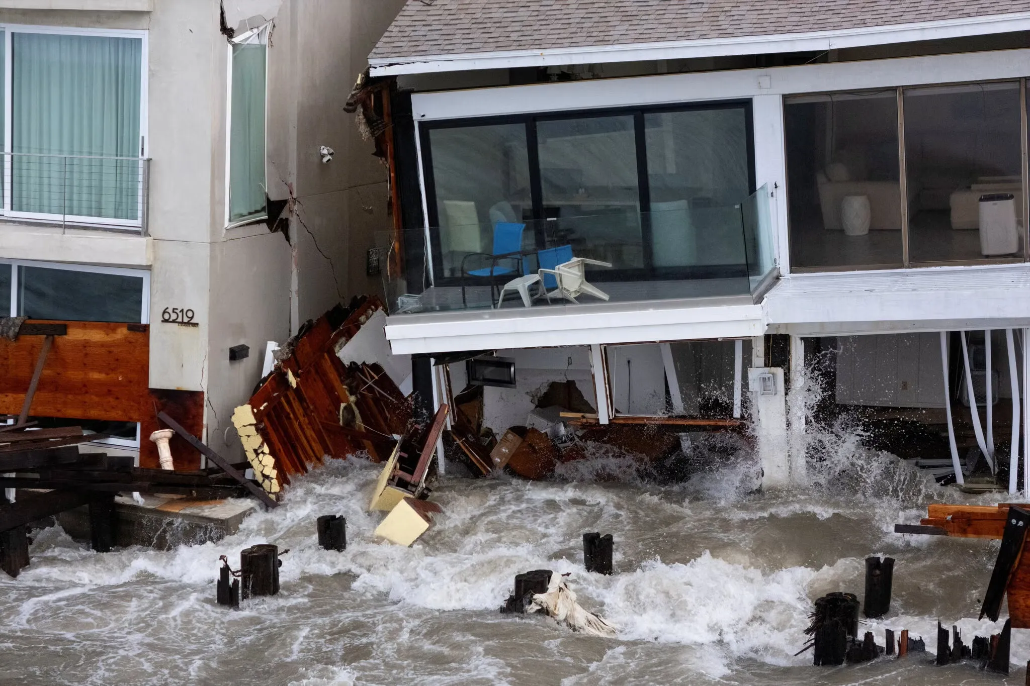 Sóng lớn do ảnh hưởng của bão Rachel đánh vào một số ngôi nhà ven biển - Ảnh: REUTERS