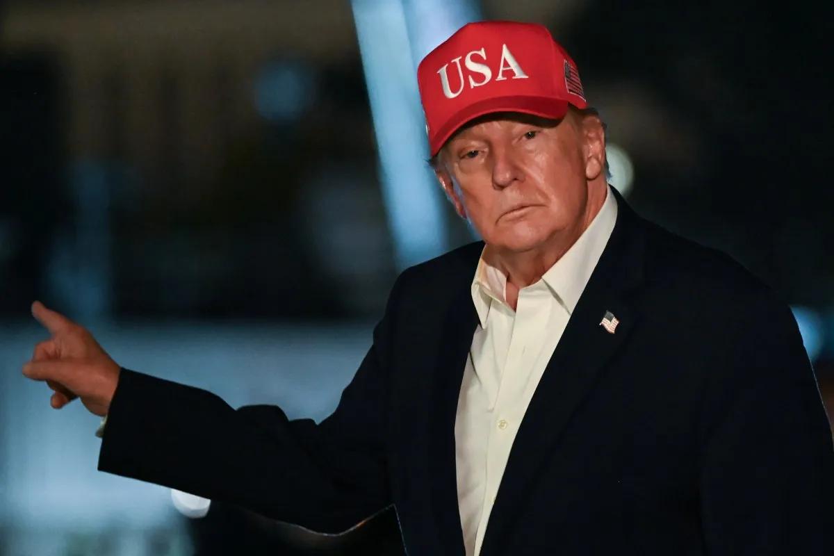 Tổng thống Mỹ Donald Trump ra hiệu khi đến Nhà Trắng bằng trực thăng Marine One. Ảnh chụp tại bãi cỏ phía nam vào rạng sáng 15-10-2026 theo giờ địa phương - Ảnh: AFP