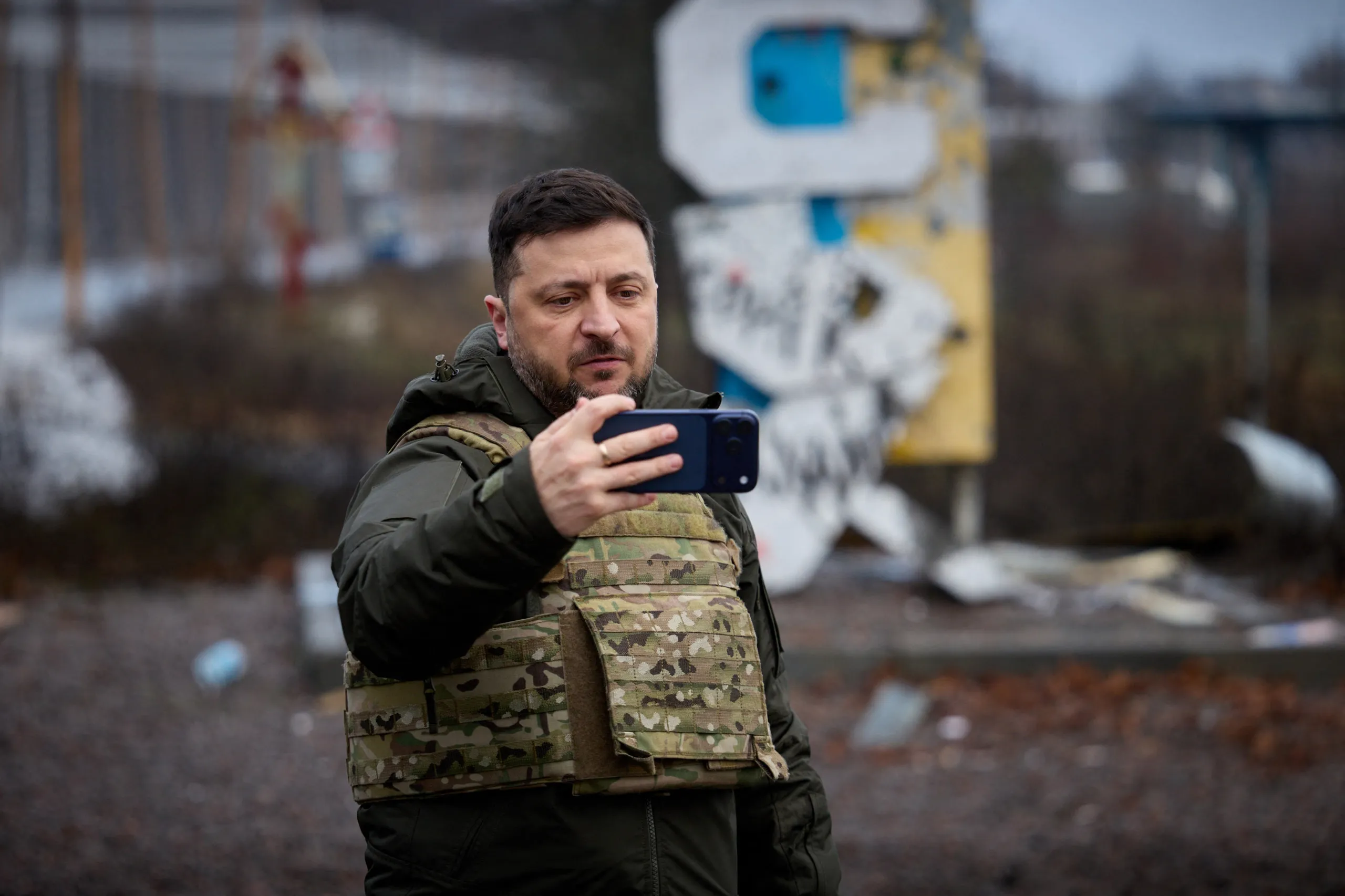 Tổng thống Zelensky dùng điện thoại ghi hình khi đến thăm thành phố Kupiansk ở vùng Kharkov vào năm 2025 - Ảnh: AFP