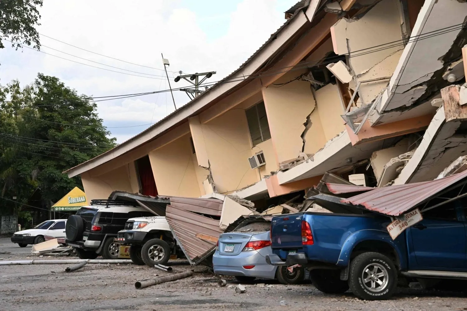 Một tòa nhà bị đổ sập và nhiều ô tô bị hư hại tại Penonome, Panama - Ảnh: AFP