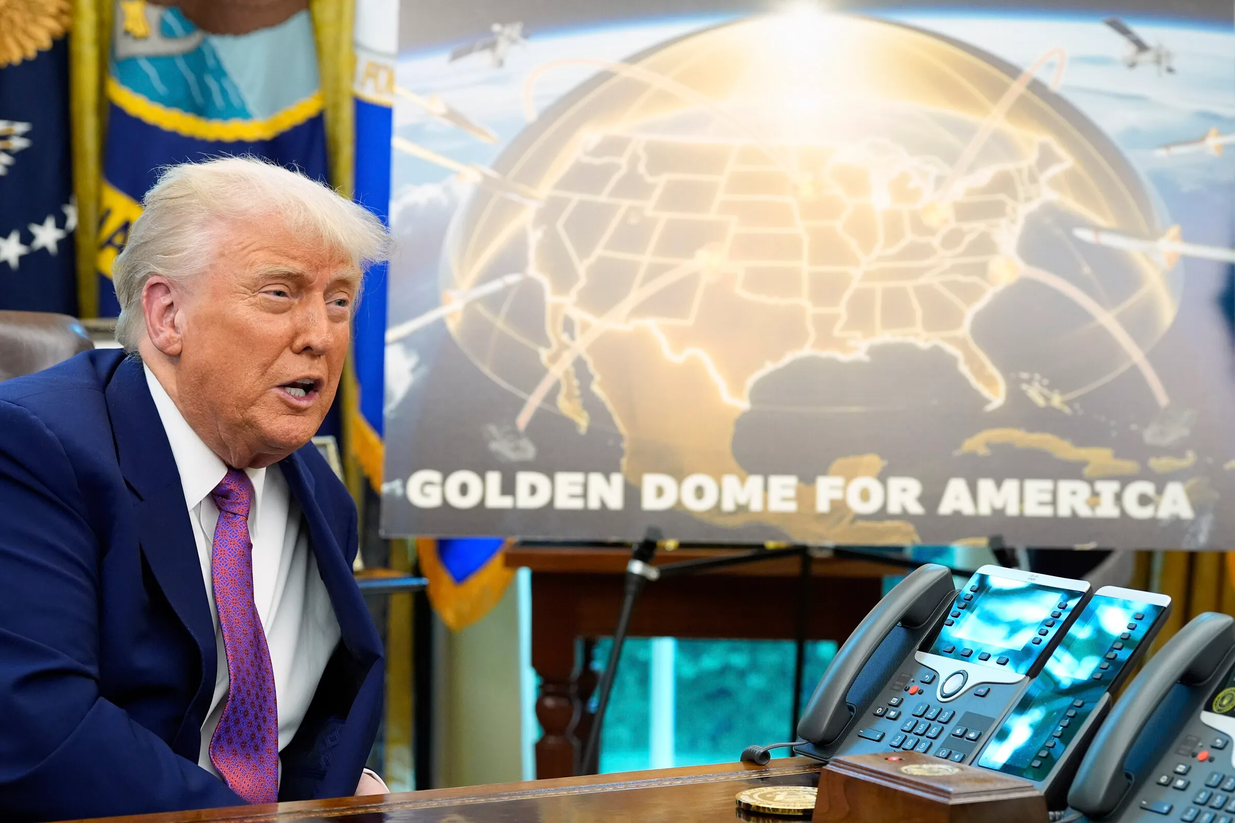 Tổng thống Donald Trump bên cạnh mô phỏng về Vòm Vàng tại Phòng Bầu dục, Nhà Trắng, hồi tháng 5/2025.