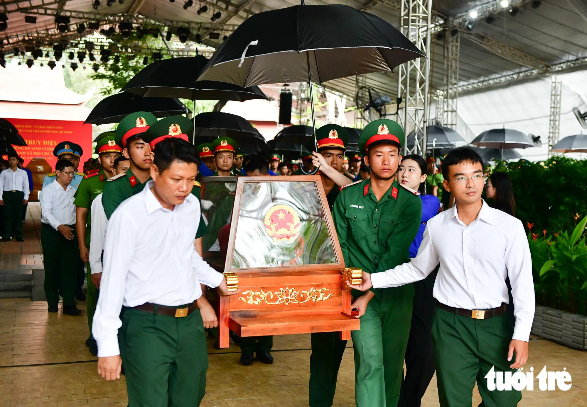Buổi sơ duyệt diễn ra với đầy đủ các nghi thức của buổi lễ chính. Hài cốt các liệt sĩ được di quan trang trọng, có dù đen che - Ảnh: LÊ PHAN