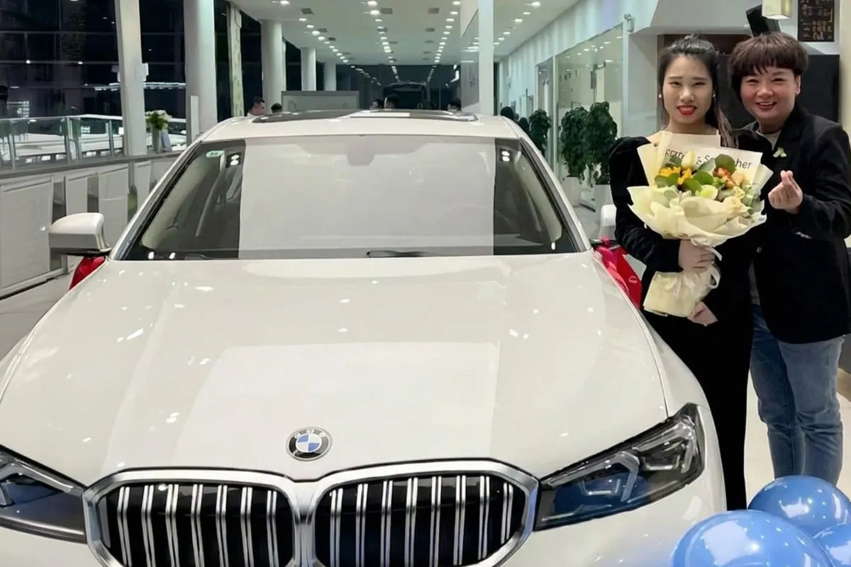 Bà Ma Yanli (ngoài cùng bên phải), đứng cạnh nhân viên Li Jie, khi đưa cô tới nhận quà là một chiếc ôtô BMW màu trắng hôm 24/9.