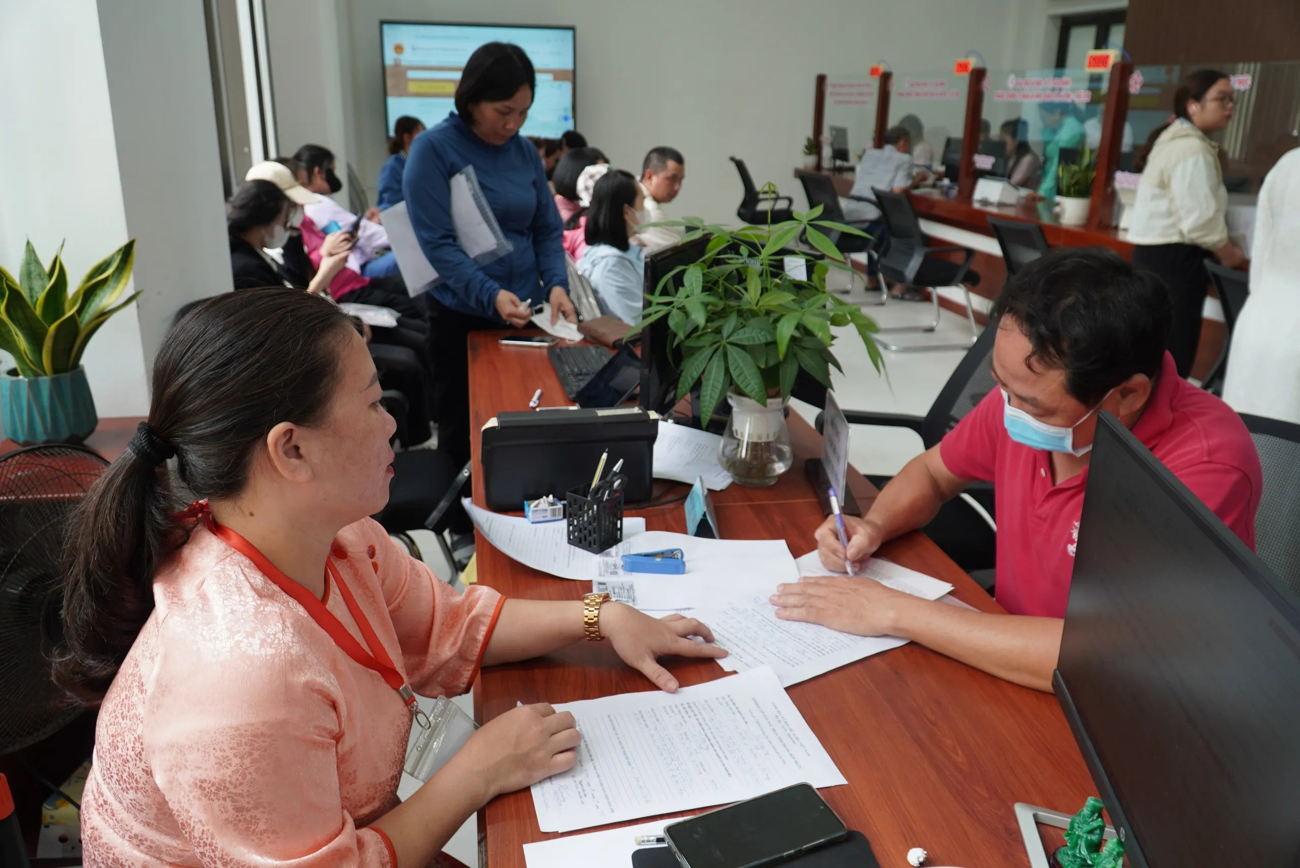 Cán bộ cấp phường ở Đà Nẵng hướng dẫn người dân làm thủ tục hành chính - Ảnh: TRƯỜNG TRUNG