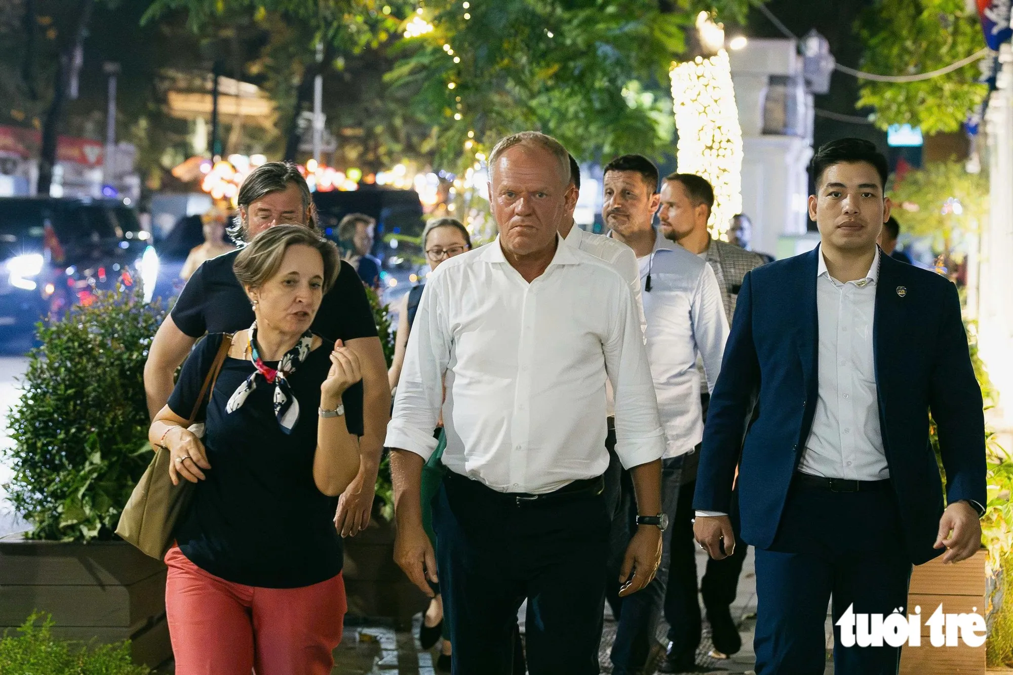 Thủ tướng Ba Lan Donald Tusk (áo trắng) vừa đi vừa trò chuyện với Đại biện lâm thời Đại sứ quán Ba Lan tại Việt Nam, bà Joanna Skoczek - Ảnh: DANH KHANG