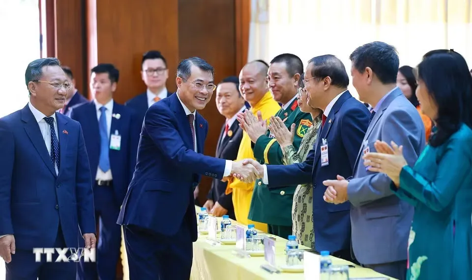Thủ tướng Lê Minh Hưng gặp cộng đồng người Việt Nam tại Lào - Ảnh:  TTXVN