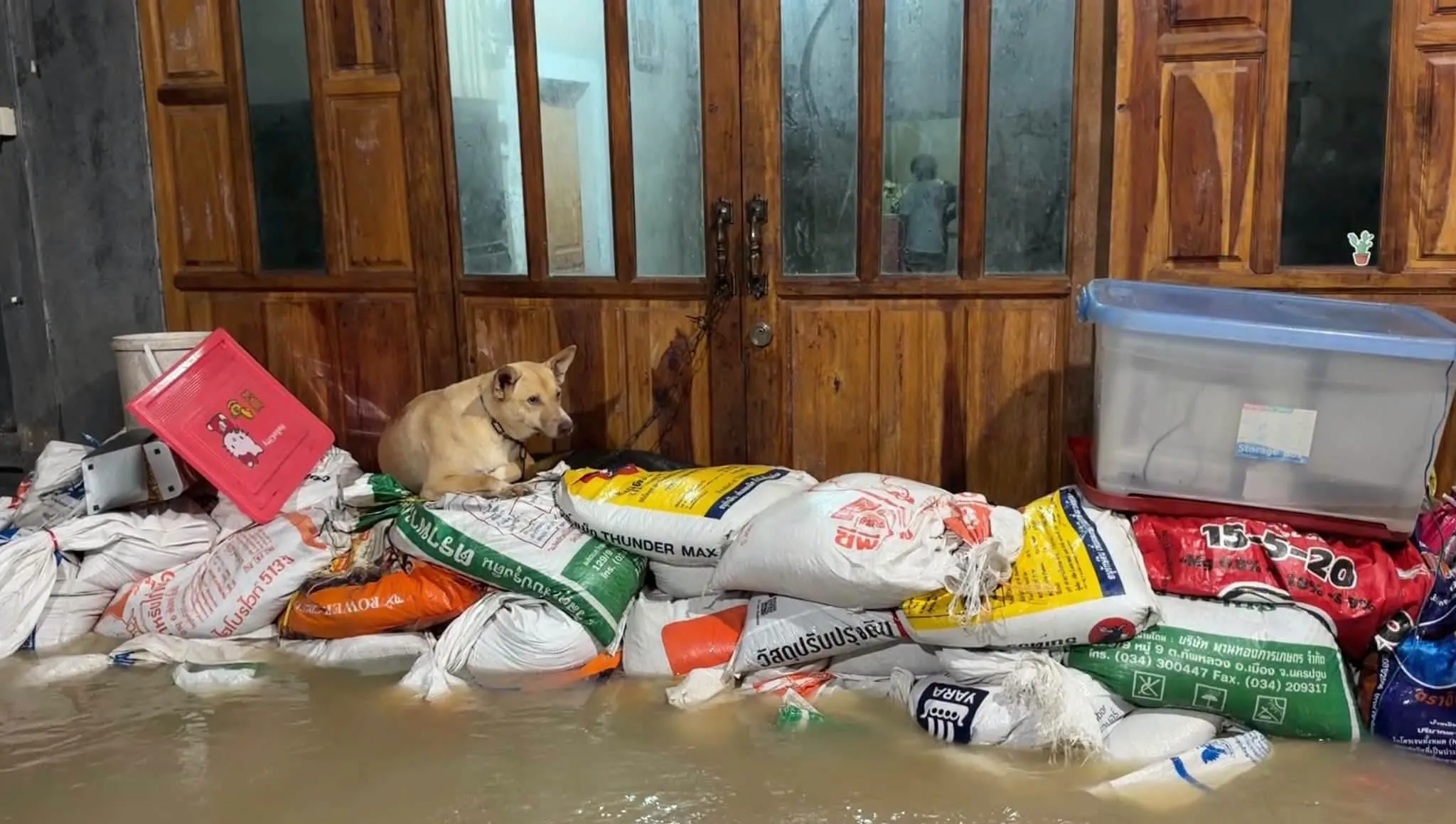 Người dân ở Rayong đắp bao cát ngăn lũ vào nhà.