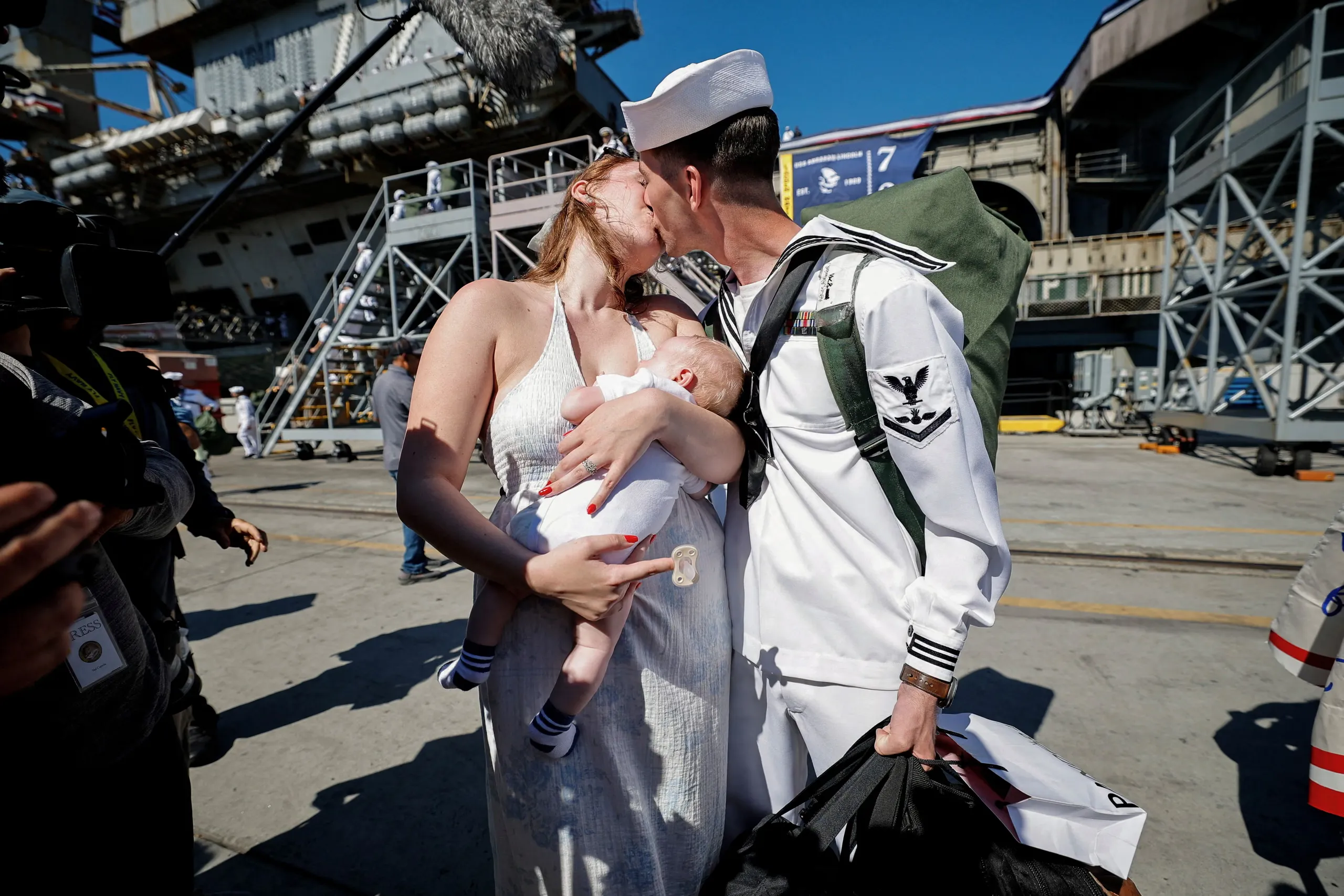 Một thủy thủ hôn vợ sau khi tàu sân bay USS Abraham Lincoln trở về căn cứ tại San Diego (Mỹ), kết thúc đợt triển khai kéo dài ở Trung Đông. Hình ảnh gợi nhớ nụ hôn lừng danh từng được xem như biểu tượng của kết thúc chiến tranh - Ảnh: REUTERS