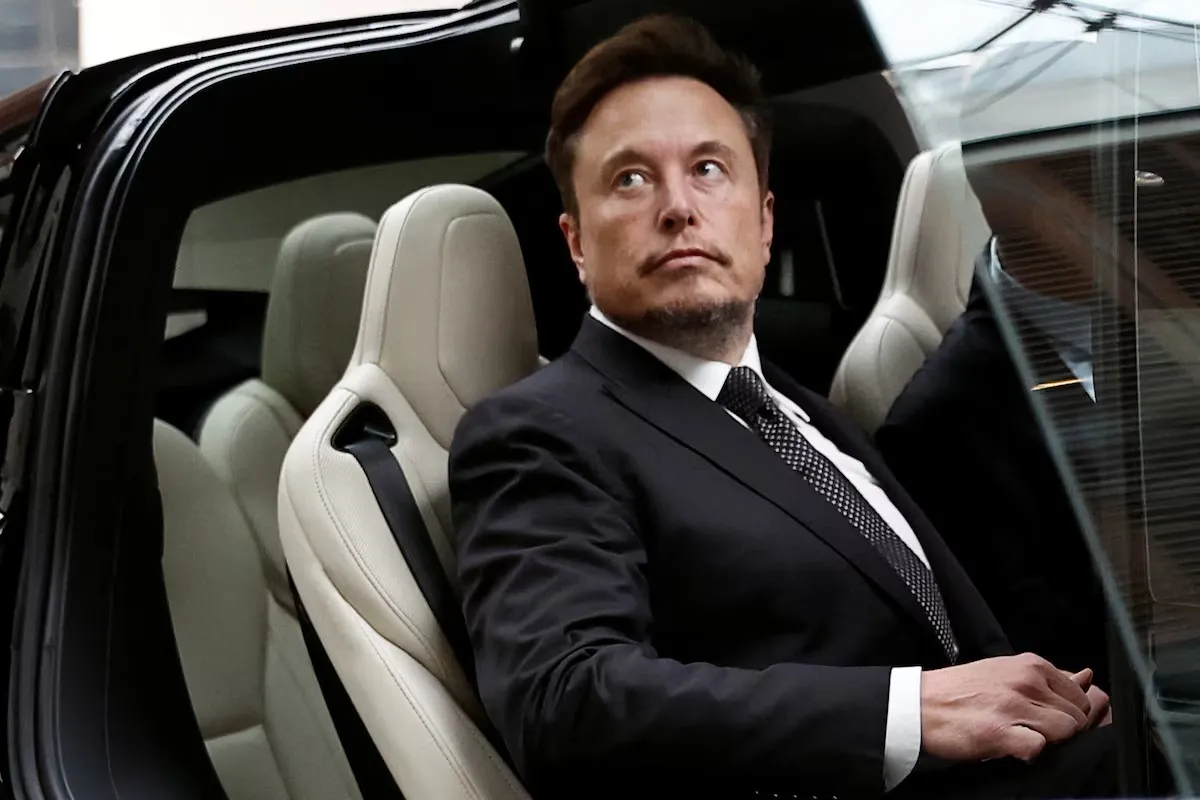 Ông Elon Musk lên xe Tesla khi rời một khách sạn ở Bắc Kinh, Trung Quốc - Ảnh: REUTERS