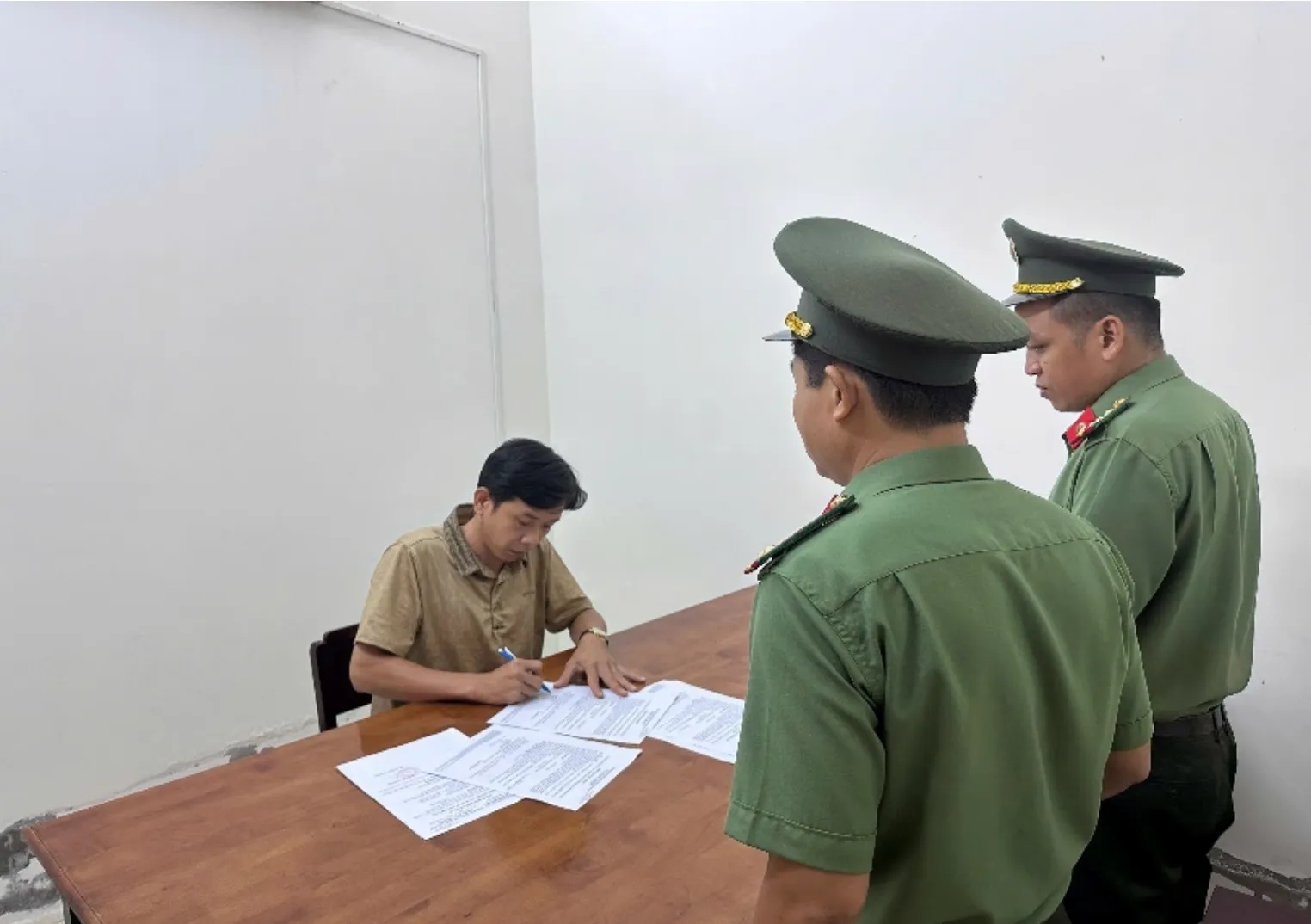 Cơ quan An ninh điều tra Công an TP Cần Thơ tống đạt các quyết định đối với bị can Dư Thành Đạt - Ảnh: Công an Cần Thơ