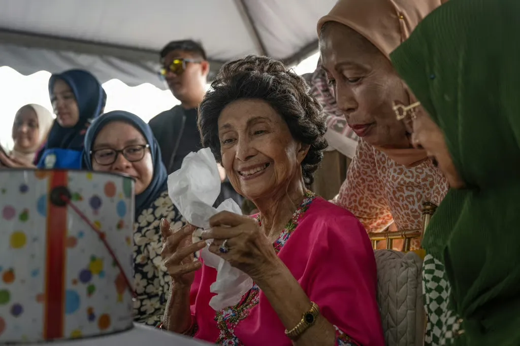 Bà Siti Hasmah bên những phụ nữ Malaysia tại một quán cà phê ở Puchong, ngoại ô Kuala Lumpur, vào tháng 5-2025 - Ảnh: AFP